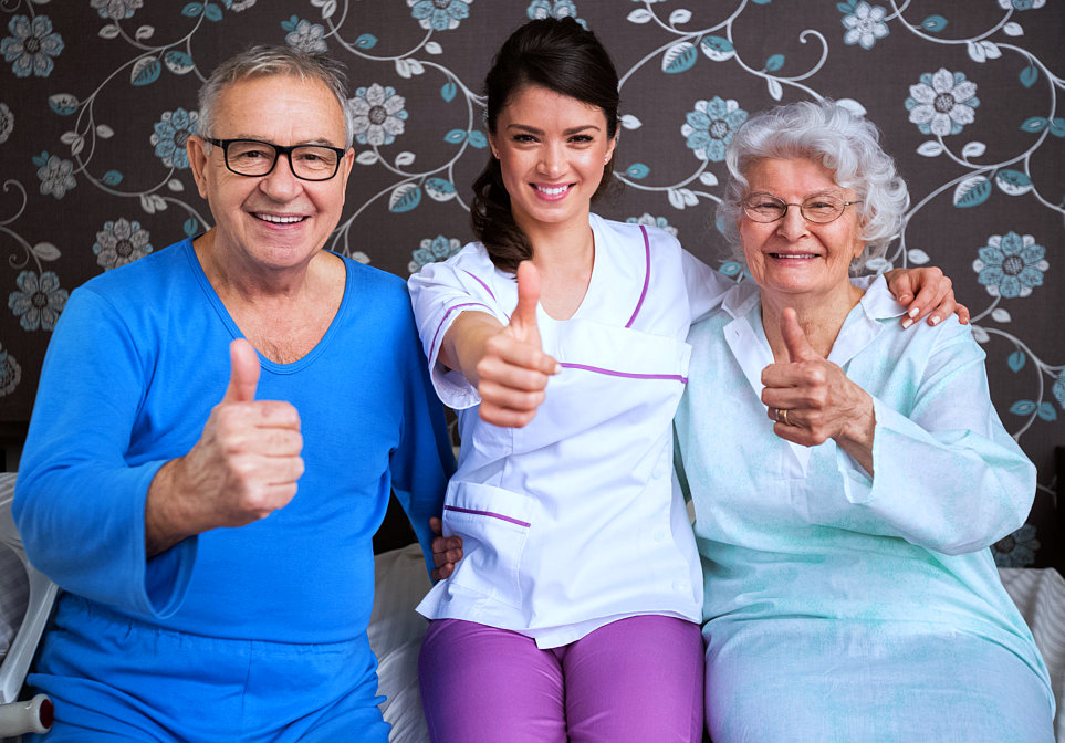 senior couple and caregiver smiling