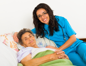 portrait of smiling elderly woman on bed with her caregiver